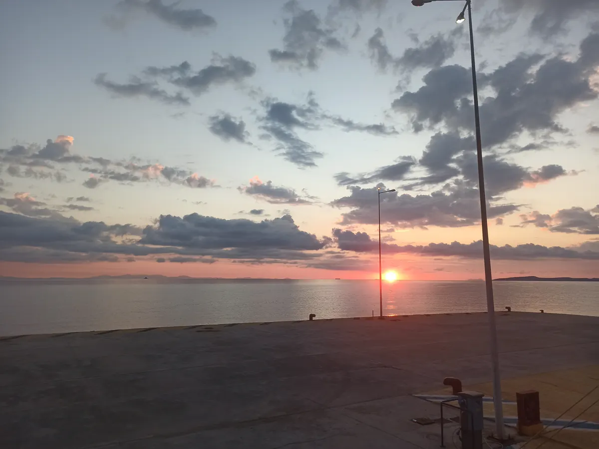 Wschód słońca nad zatoką widziany z nabrzeża portu