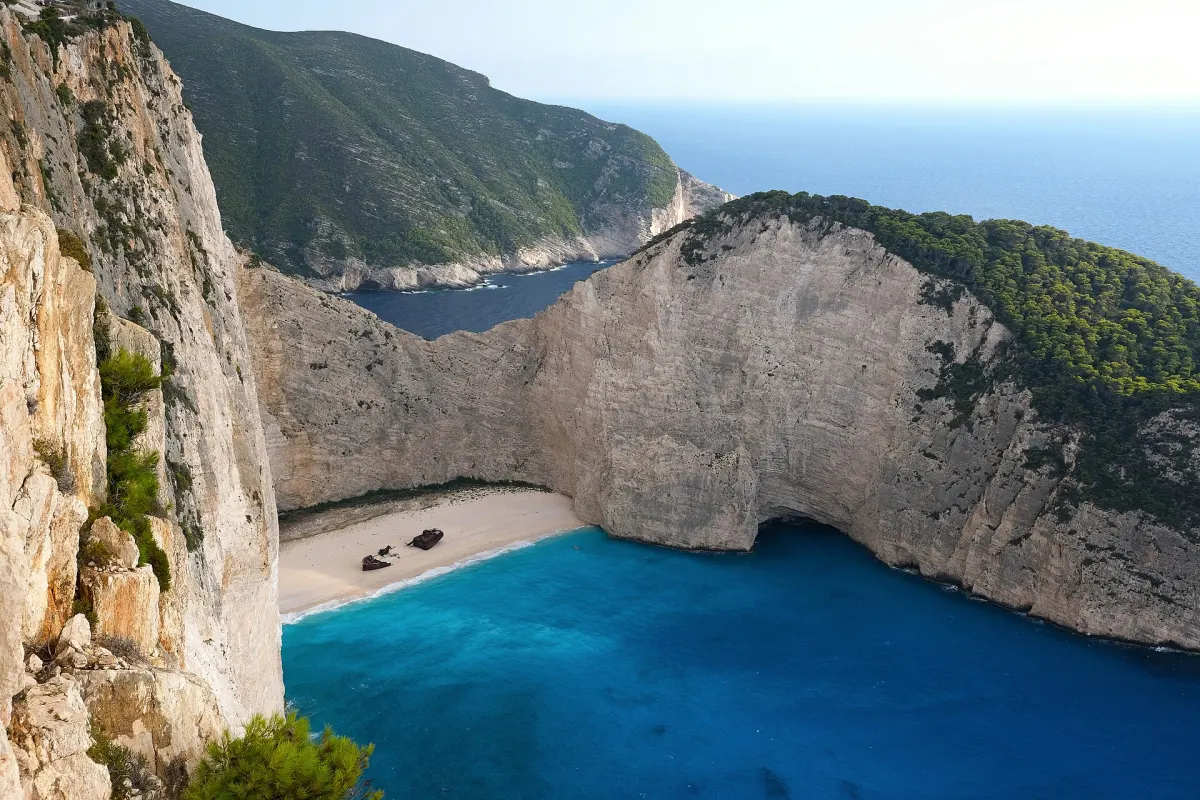 Zatoka Navagio na Zakynthos: biała plaża z wrakiem statku między wysokimi klifami